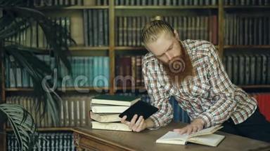 在图书馆里读一本书，用平板电脑准<strong>备考</strong>试的小胡子学生